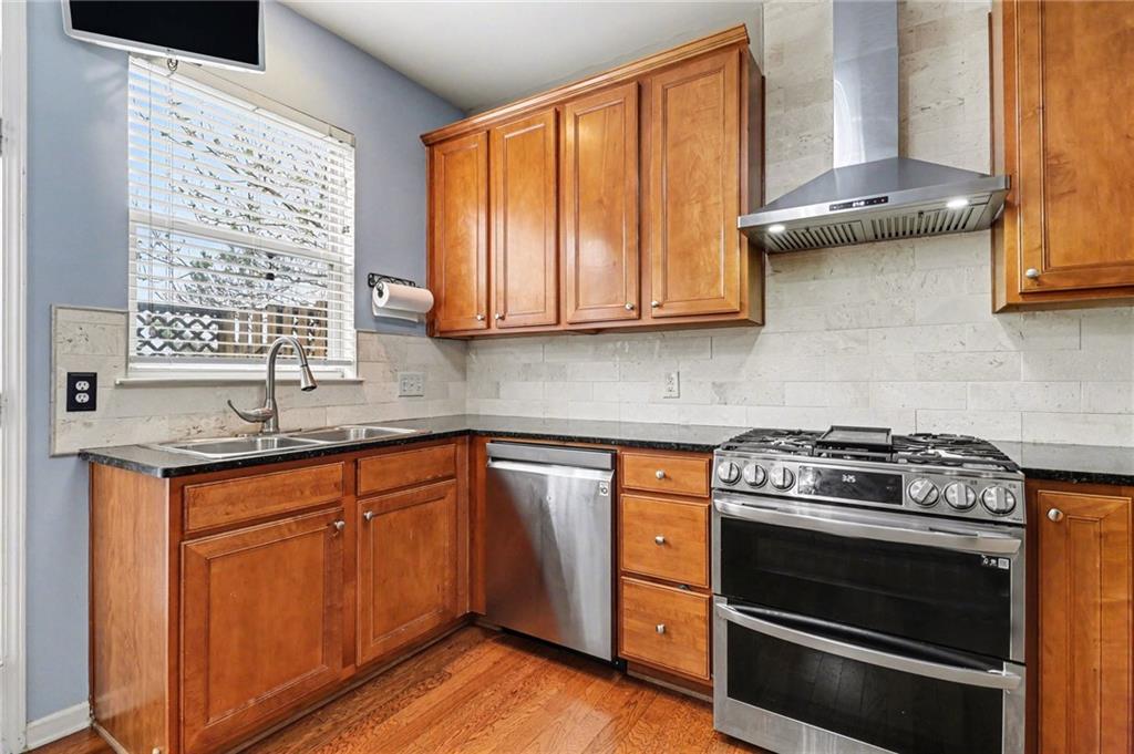 1180 Ridenour Boulevard, Unit 5 Kennesaw, GA 30152 - Photo 7 of 22 a kitchen with granite countertop wooden cabinets stainless steel appliances and a window