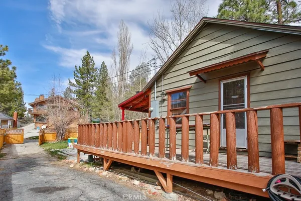 a view of wooden house with a wooden fence