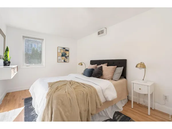 a bedroom with a bed and wooden floor