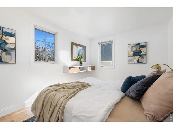 a bedroom with a bed and a painting on the wall