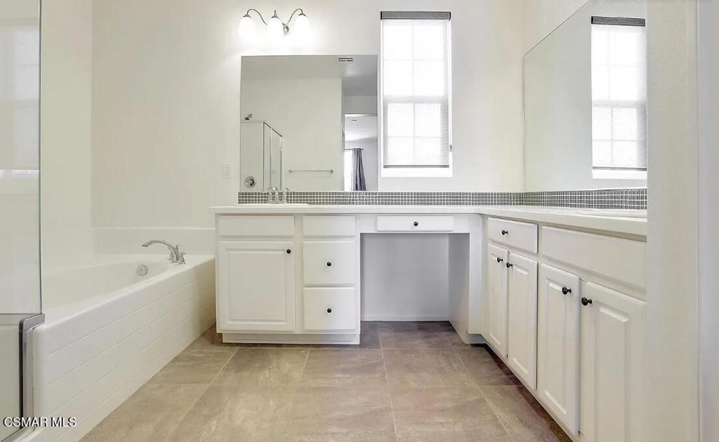 458 Stratus Lane, Unit 5 Simi Valley, CA 93065 - Photo 8 of 13 a spacious bathroom with a bathtub sink and mirror