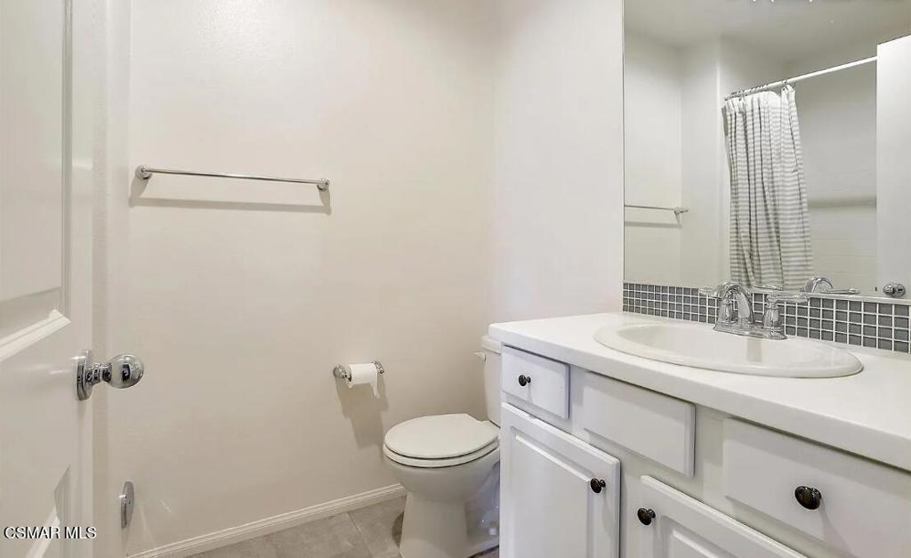 458 Stratus Lane, Unit 5 Simi Valley, CA 93065 - Photo 10 of 13 a bathroom with a granite countertop sink toilet and a mirror
