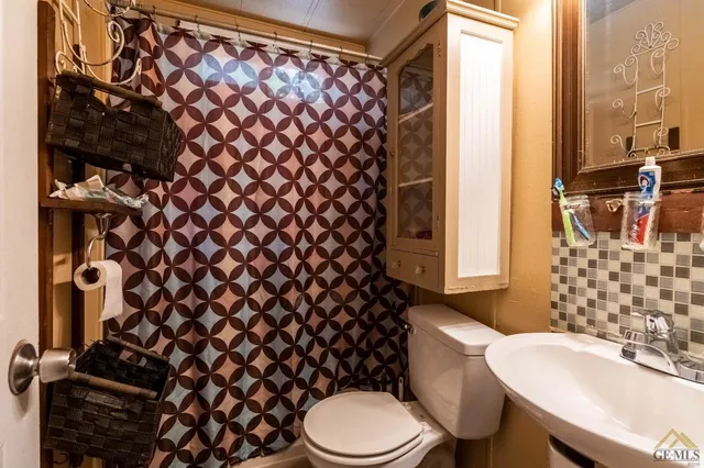 a white toilet sitting next to a shower curtain