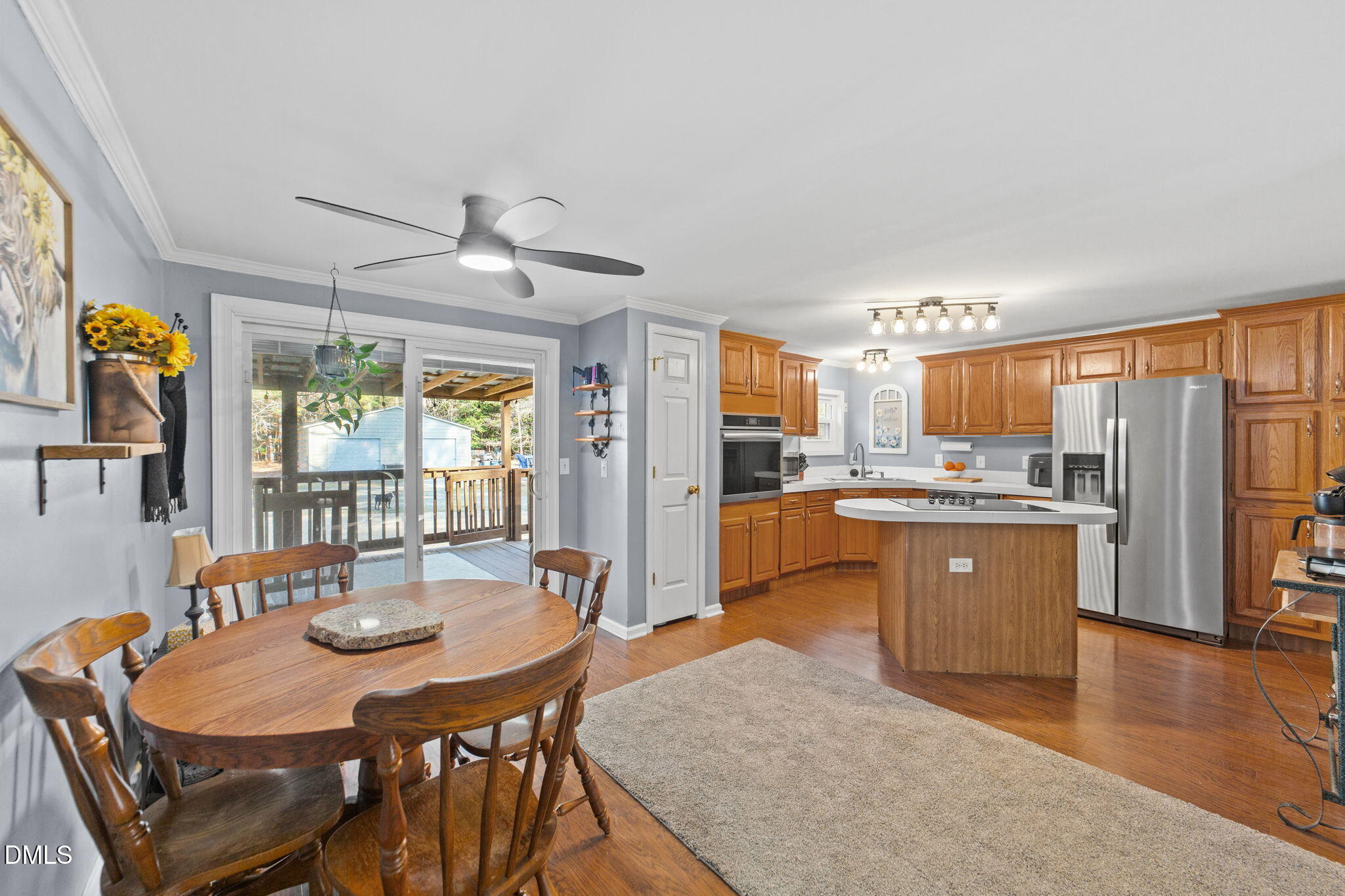2465 Shoeheel Road Selma, NC 27576 - Photo 5 of 36 a kitchen with stainless steel appliances granite countertop a stove a refrigerator a kitchen island a dining table and chairs with wooden floor