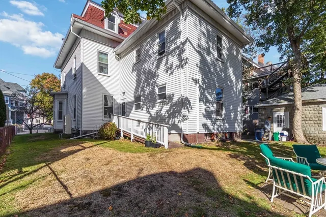 a backyard of a house with fountain table and chairs