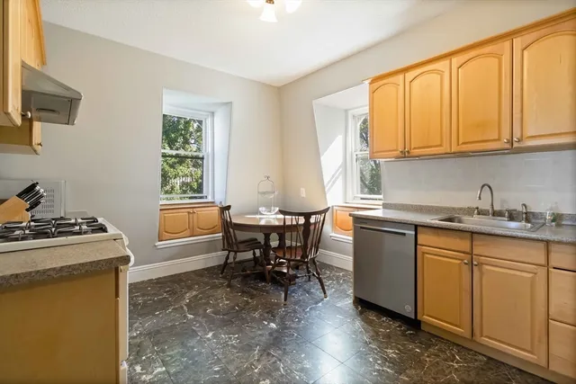 a kitchen with granite countertop a sink stove and cabinets