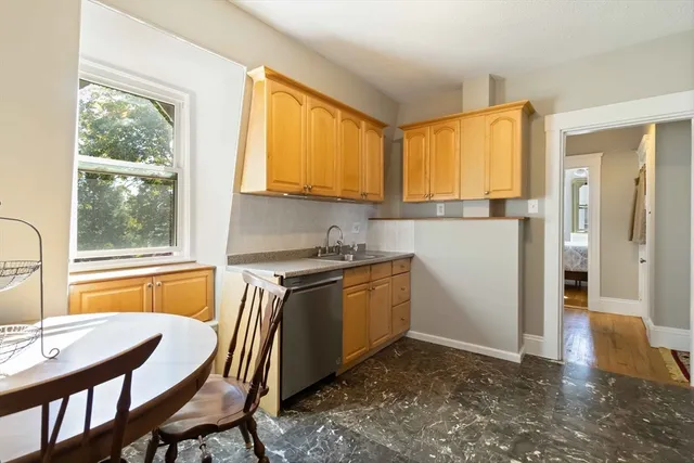 a kitchen with a table chairs sink and cabinets