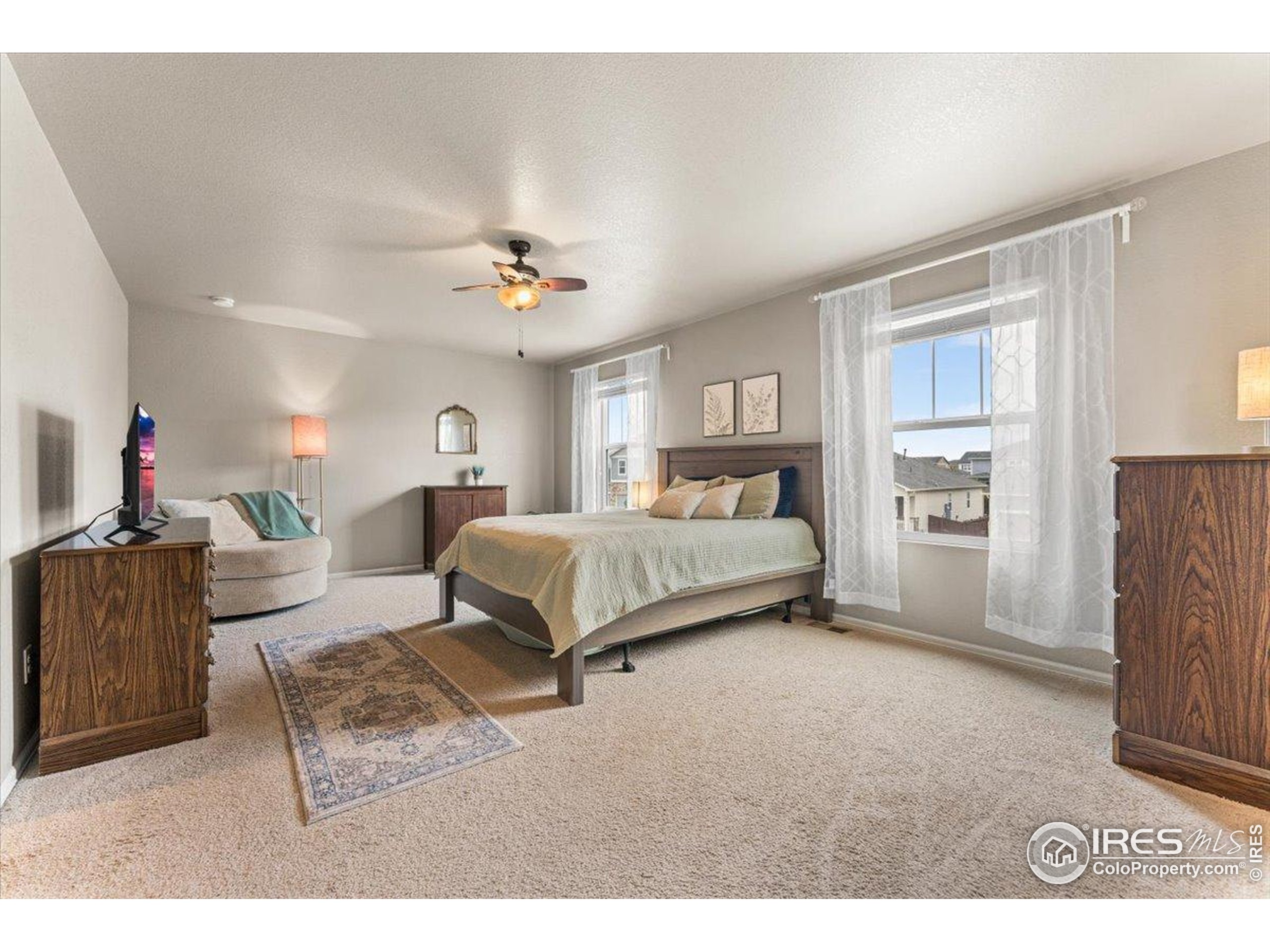6747 Grainery Road Timnath, CO 80547 - Photo 13 of 42 a bedroom with a bed and a chandelier