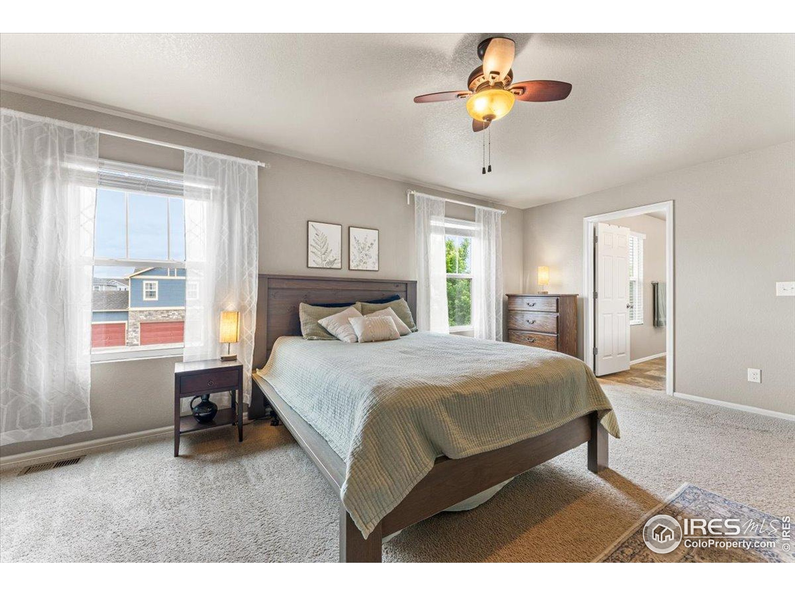 6747 Grainery Road Timnath, CO 80547 - Photo 14 of 42 a bedroom with a bed a chandelier and a window