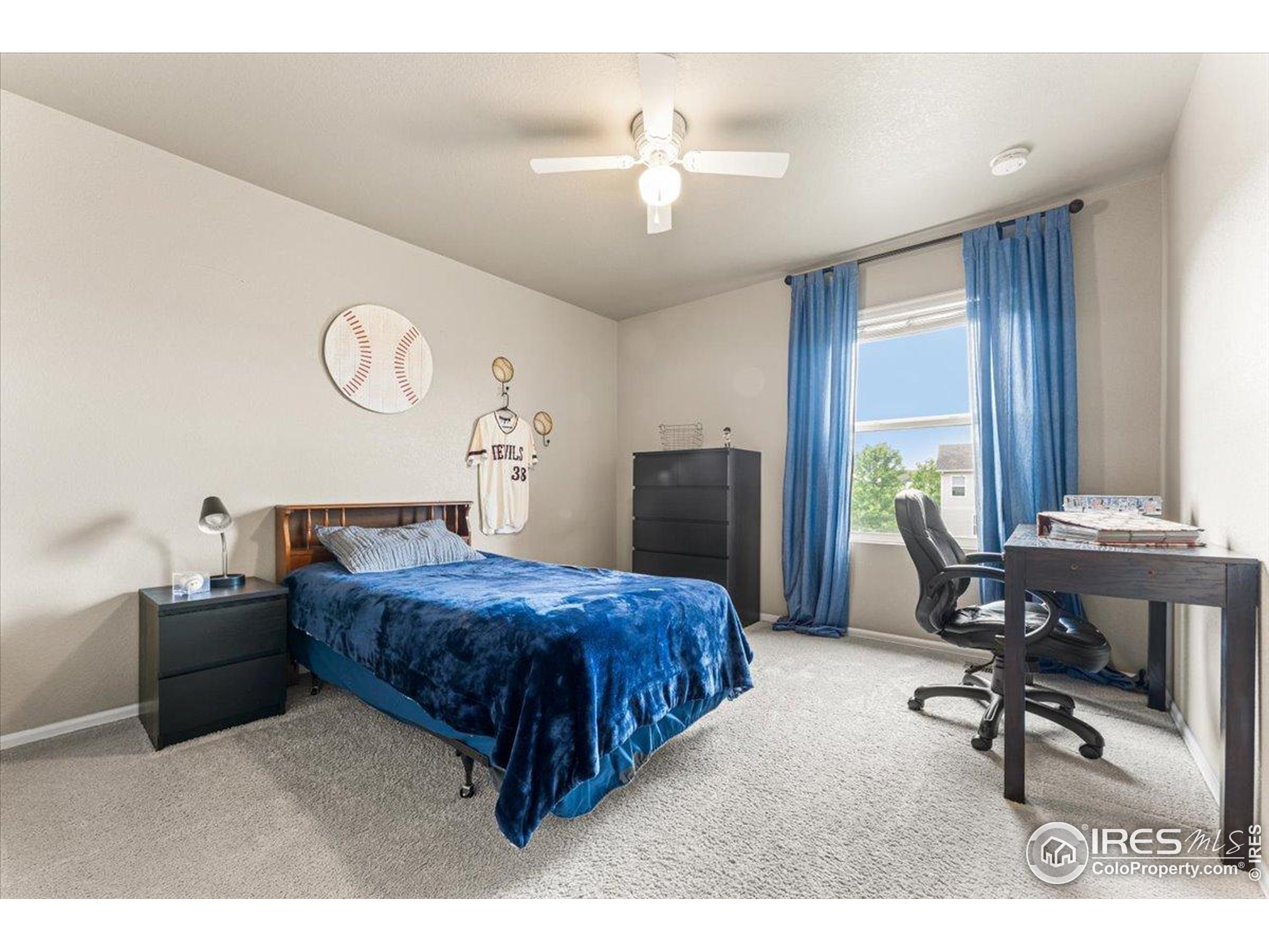 6747 Grainery Road Timnath, CO 80547 - Photo 22 of 42 a bedroom with a bed and a chandelier