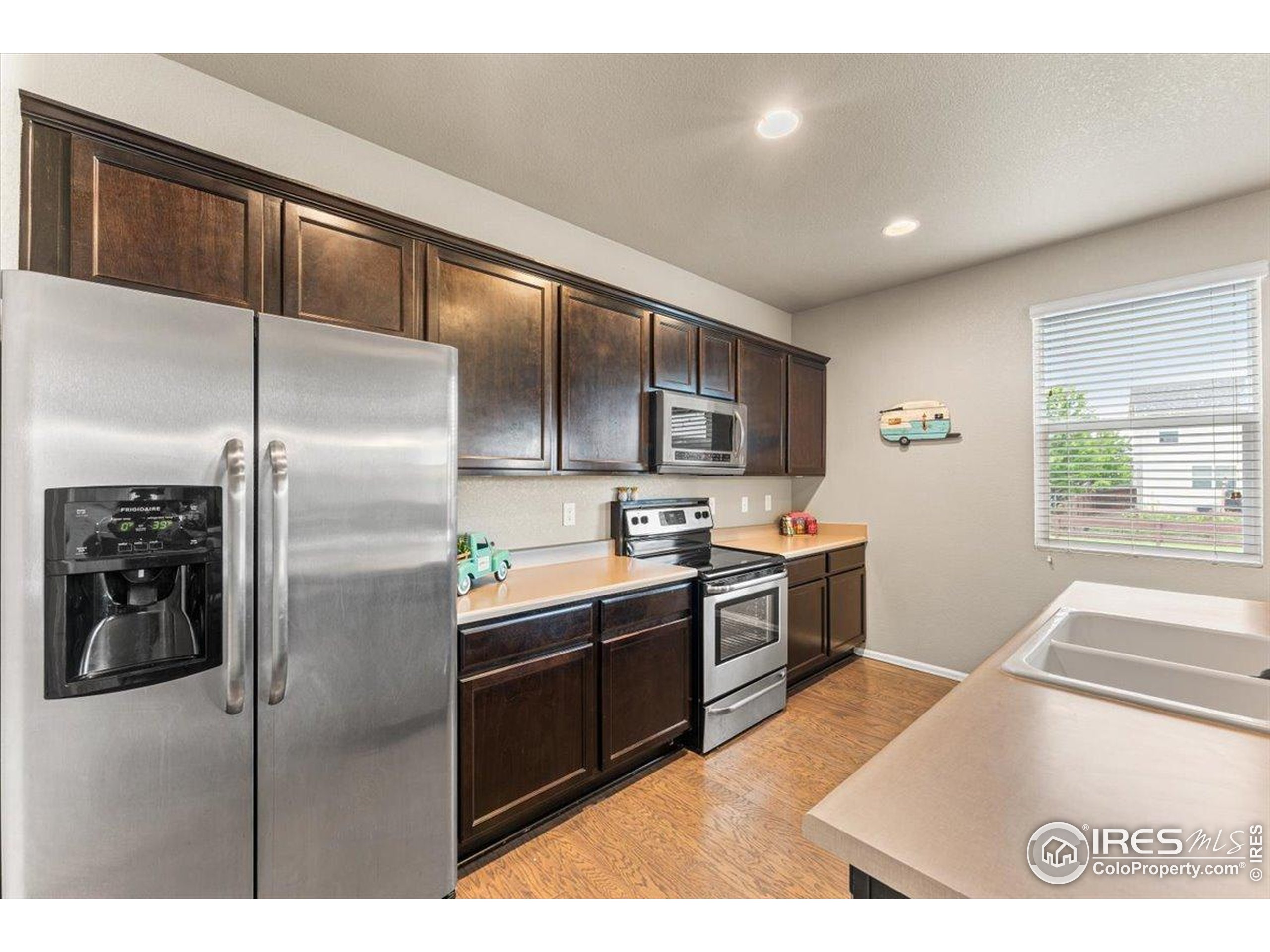 6747 Grainery Road Timnath, CO 80547 - Photo 26 of 42 a kitchen with kitchen island a counter top space cabinets stainless steel appliances and a window