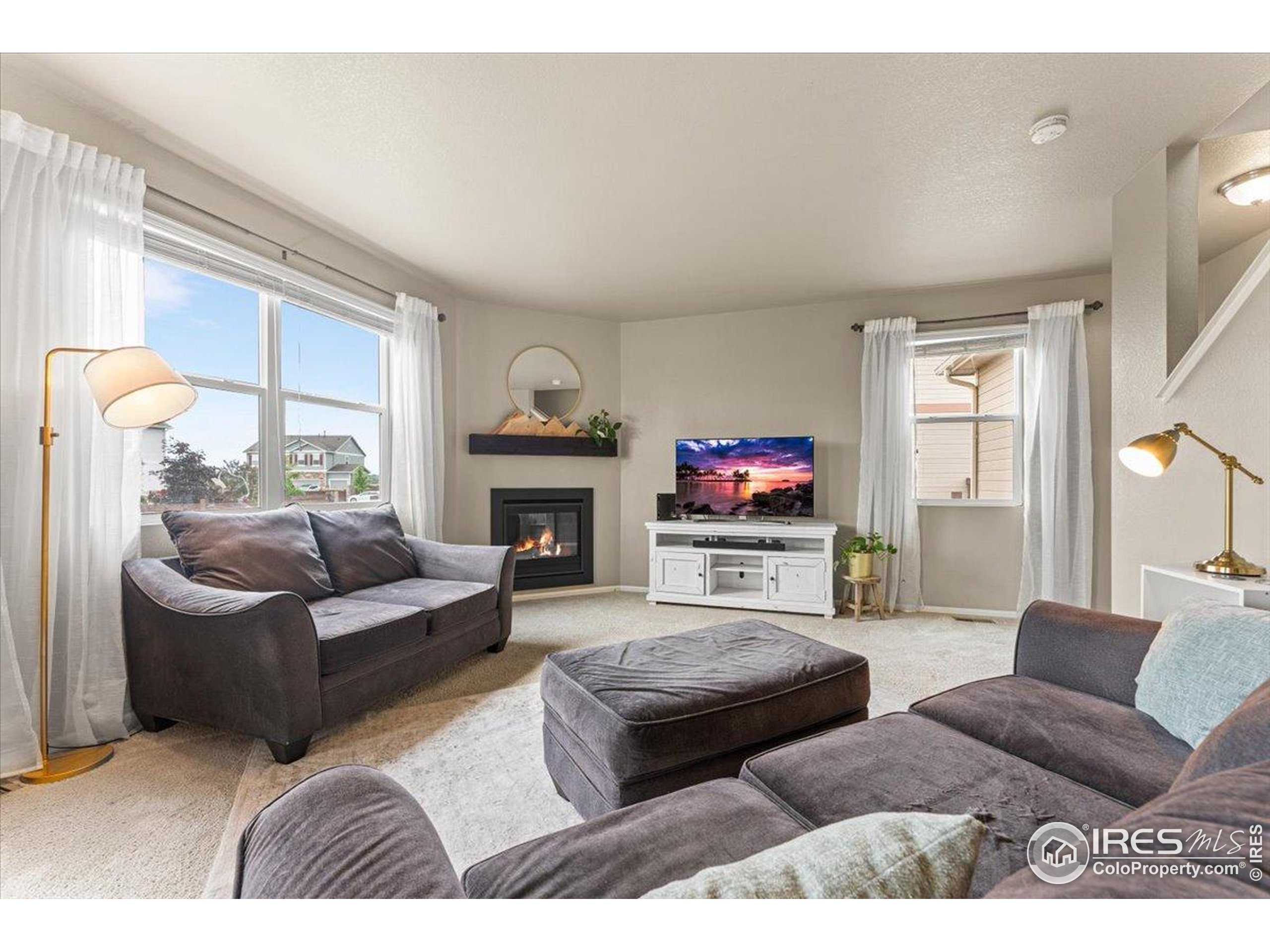 6747 Grainery Road Timnath, CO 80547 - Photo 4 of 42 a living room with fireplace furniture and a flat screen tv