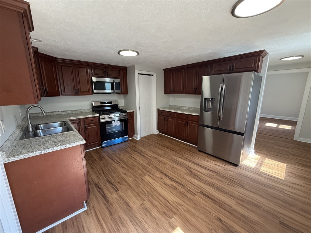 3 Mill Street Shirley, MA 01464 - Photo 24 of 27 a kitchen with stainless steel appliances granite countertop a refrigerator sink and stove