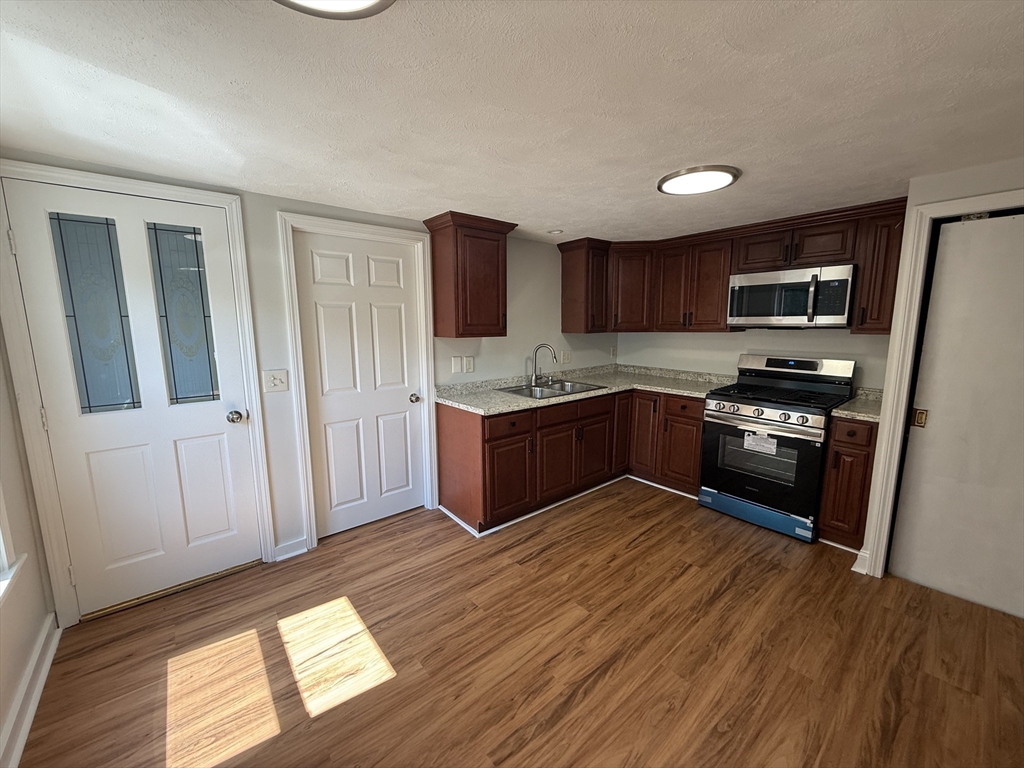 3 Mill Street Shirley, MA 01464 - Photo 25 of 27 a kitchen with stainless steel appliances granite countertop a stove a sink and a refrigerator