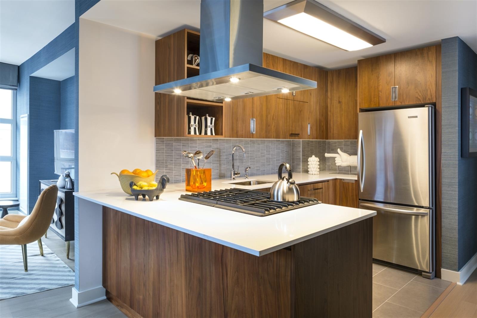 a kitchen with stainless steel appliances a sink a refrigerator and wooden cabinets