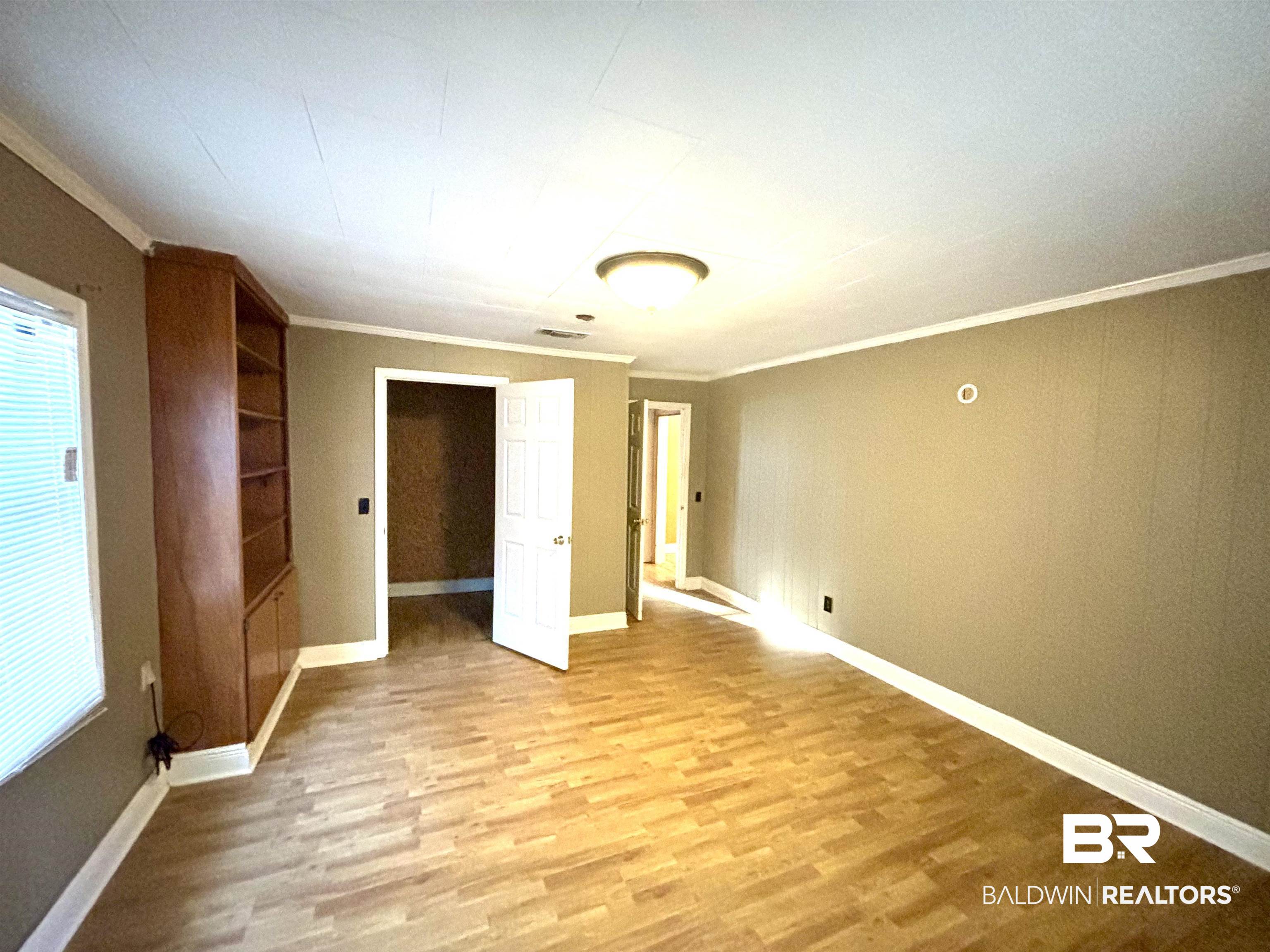 17495 County Road 48 Robertsdale, AL 36567 - Photo 26 of 37 Unfurnished bedroom featuring light wood-type flooring and ornamental molding