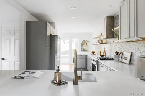 a kitchen with granite countertop a sink appliances and cabinets