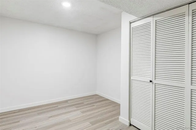 a view of a small space with wooden floor and a window