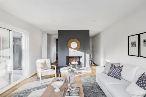 a living room with furniture a fireplace and a table