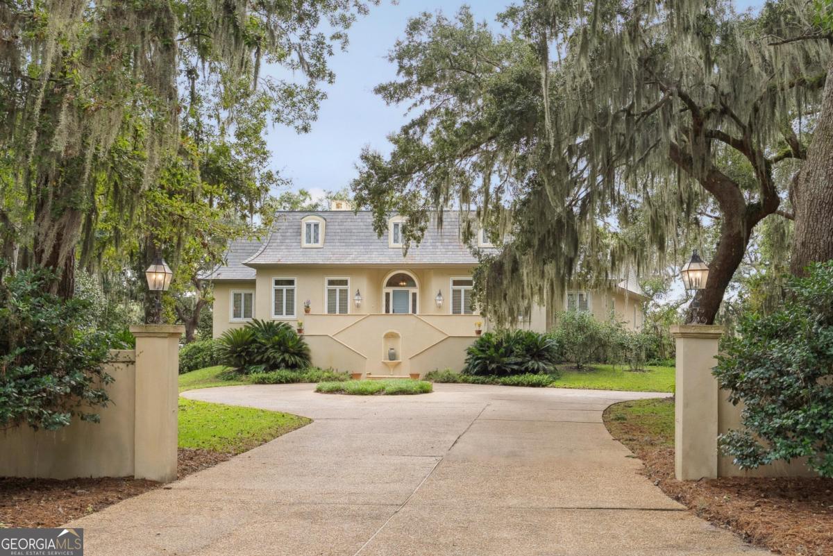 a front view of a house with a yard and trees