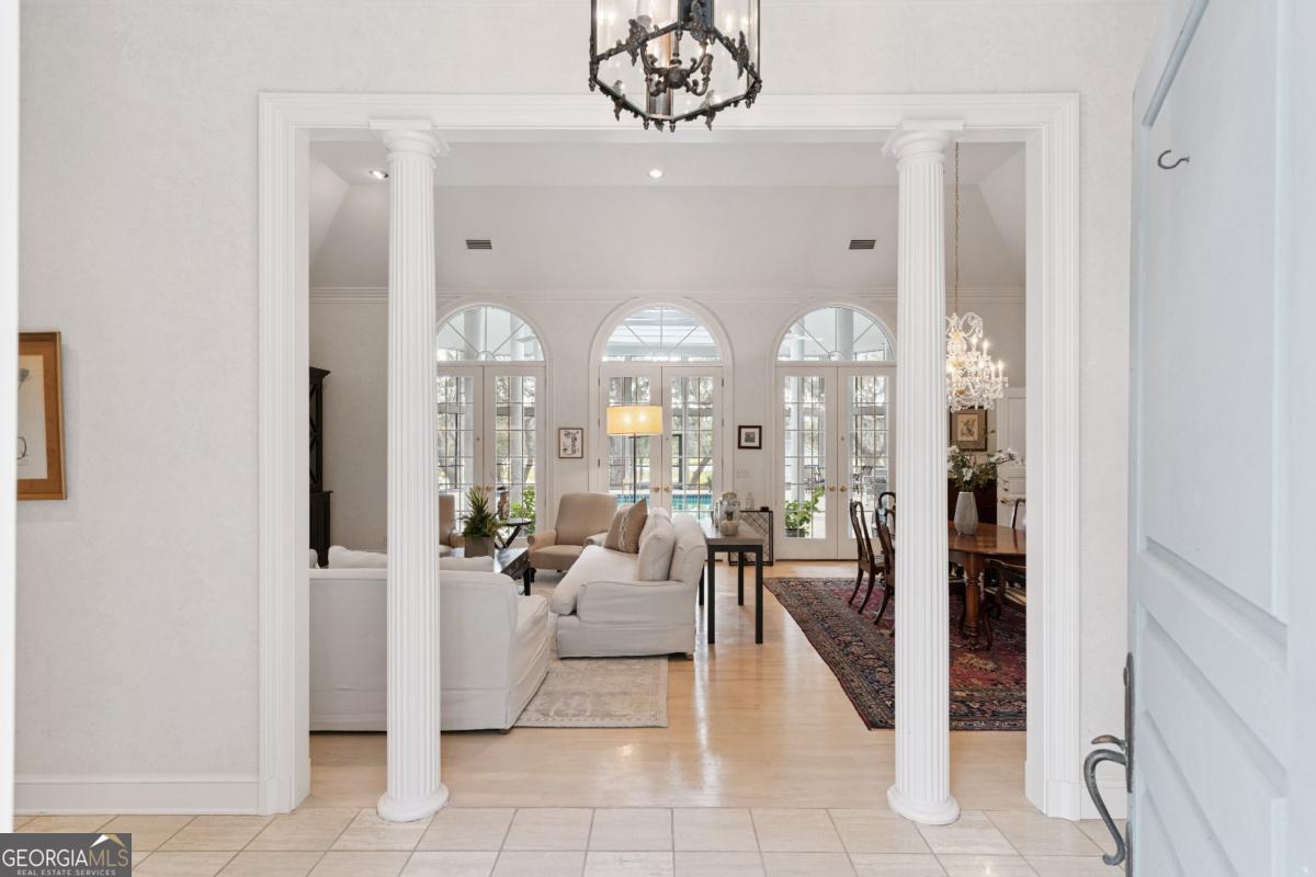 160 Hampton Point Drive St. Simons Island, GA 31522 - Photo 12 of 59 a living room with furniture a chandelier and a large mirror