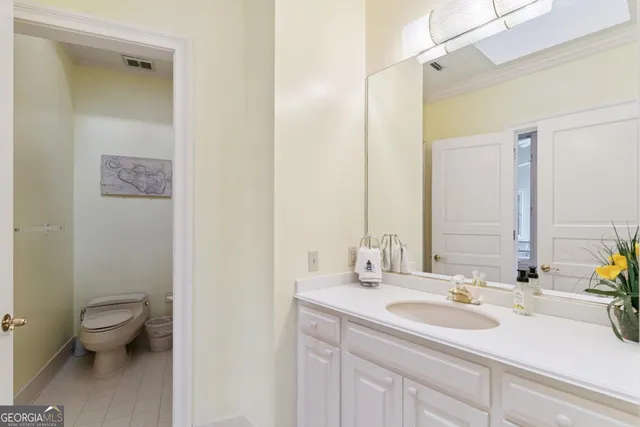a bathroom with a sink a toilet and mirror