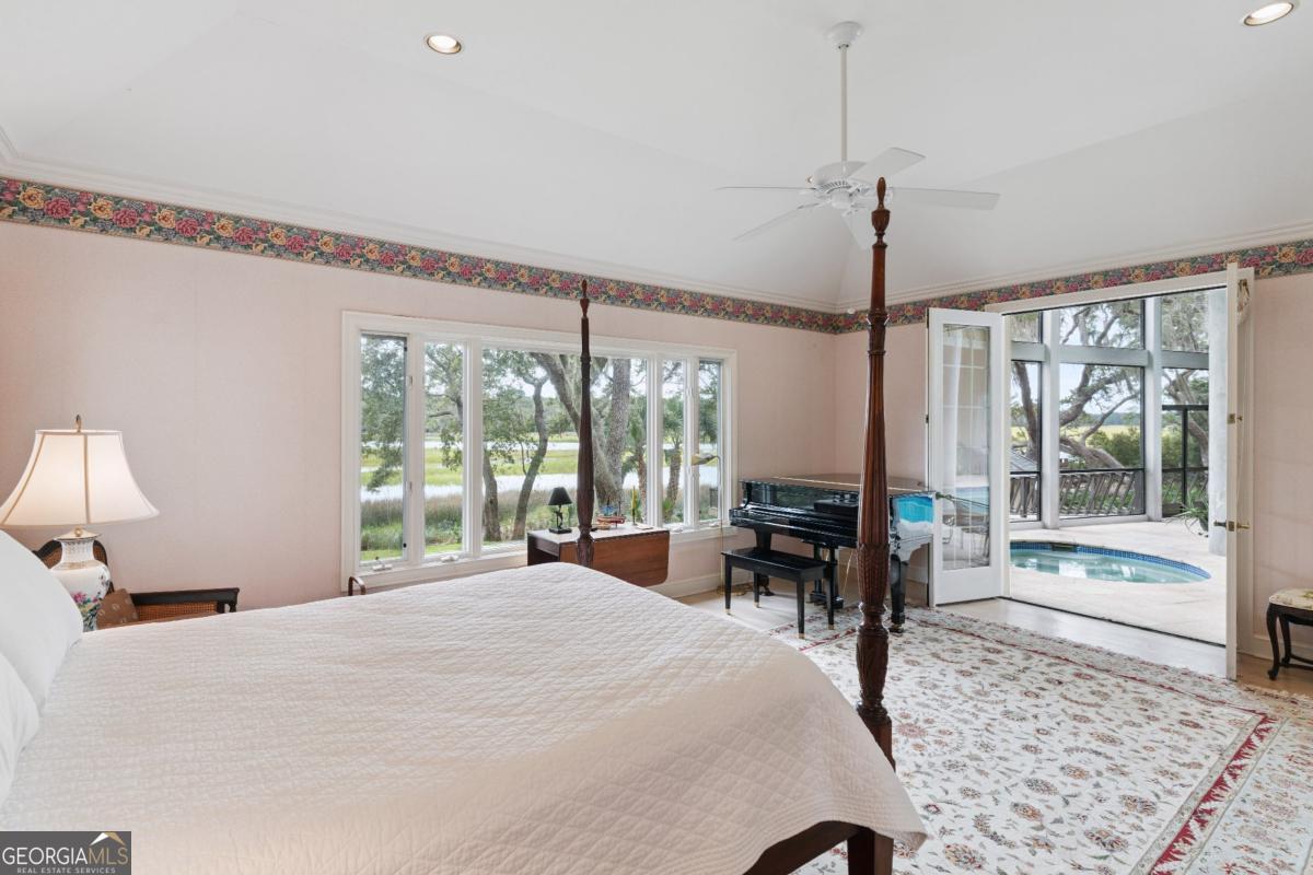 160 Hampton Point Drive St. Simons Island, GA 31522 - Photo 25 of 59 a bedroom with a bed large window with table and chair