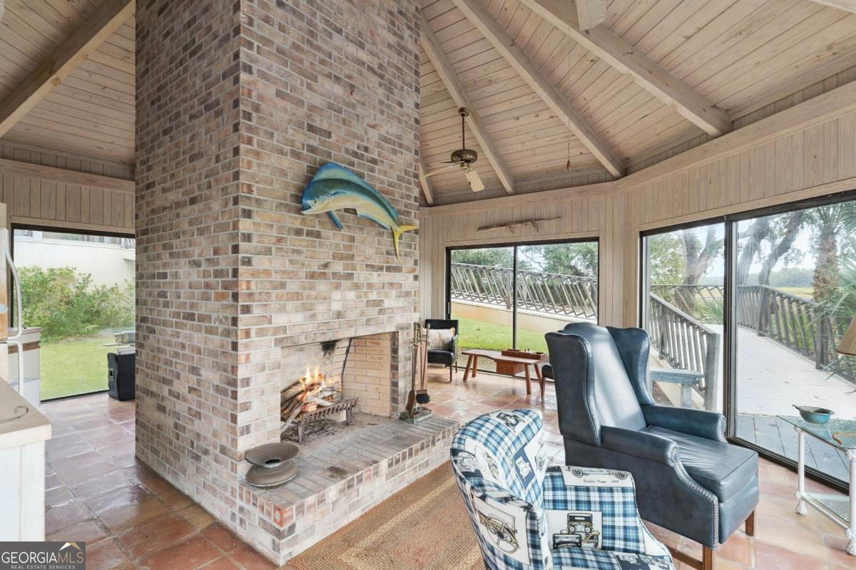 160 Hampton Point Drive St. Simons Island, GA 31522 - Photo 54 of 59 a living room with furniture a fireplace and a floor to ceiling window