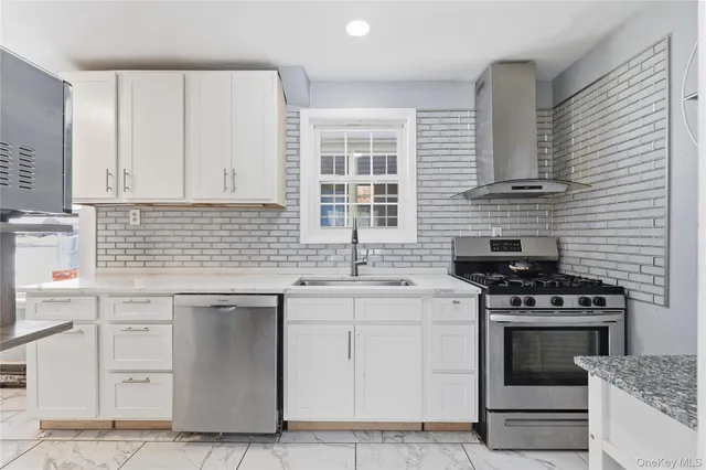 a kitchen with stainless steel appliances a stove sink and cabinets