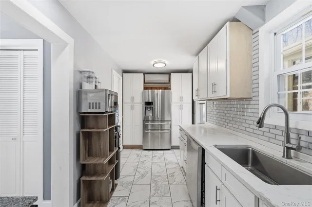 a kitchen with a refrigerator sink and cabinets
