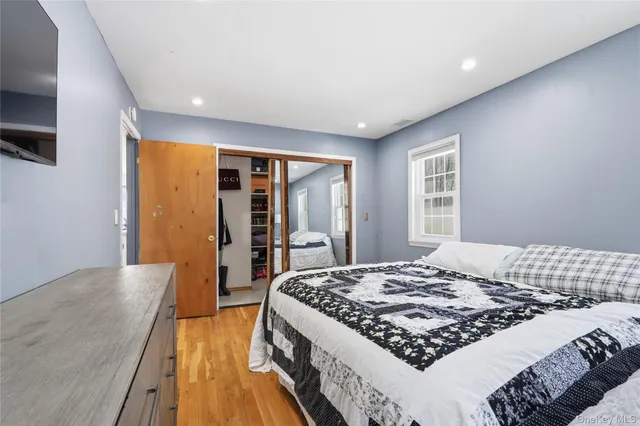 a large bedroom with a bed and wooden floor