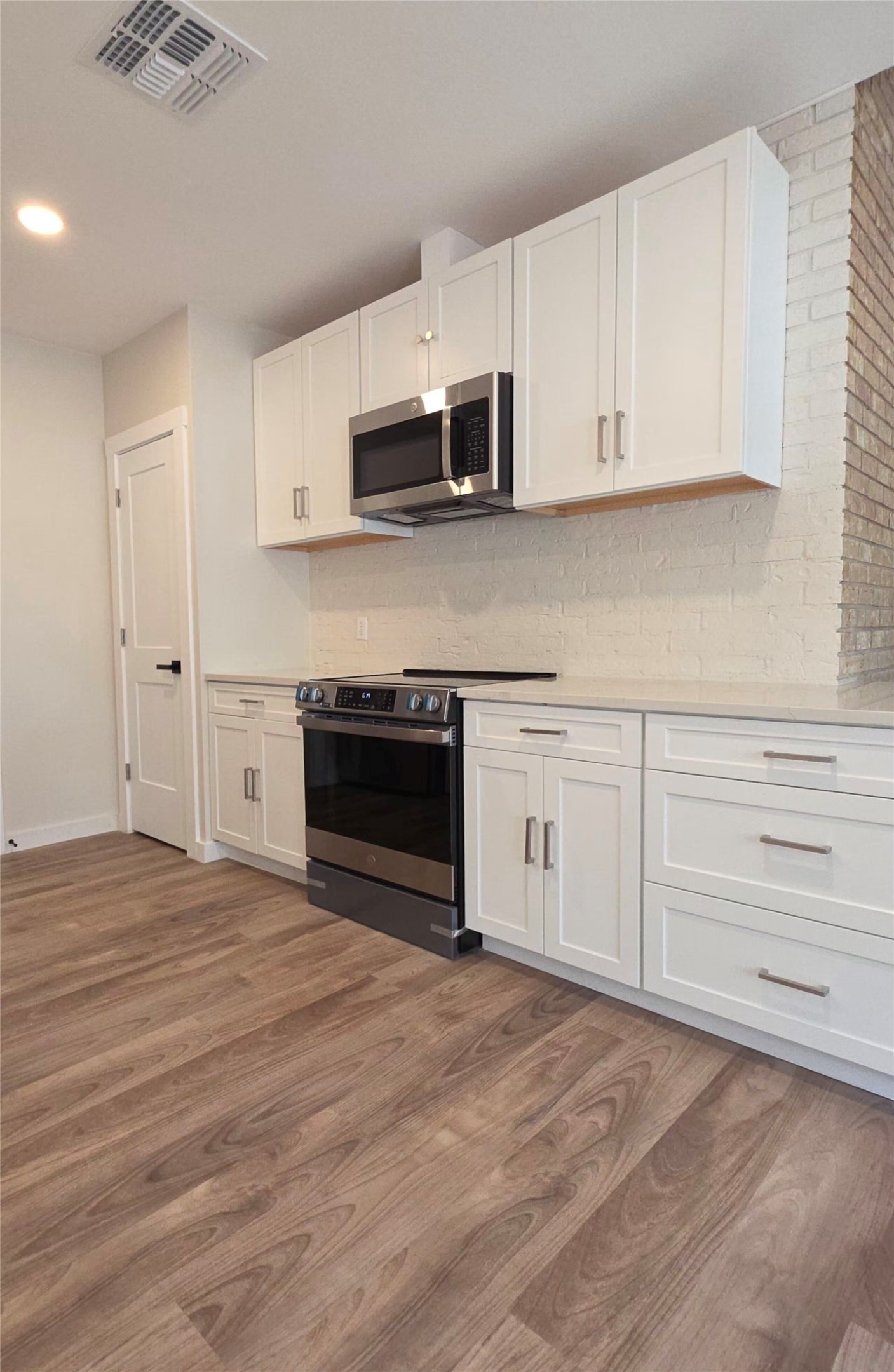 109 Cernosek Road La Grange, TX 78945 - Photo 7 of 32 a kitchen with stainless steel appliances granite countertop a stove a microwave and white cabinets
