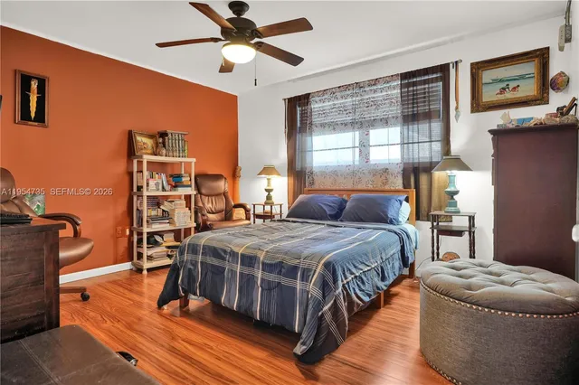 a bedroom with a bed gym equipment and a large window