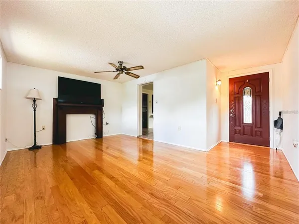 a view of empty room with wooden floor