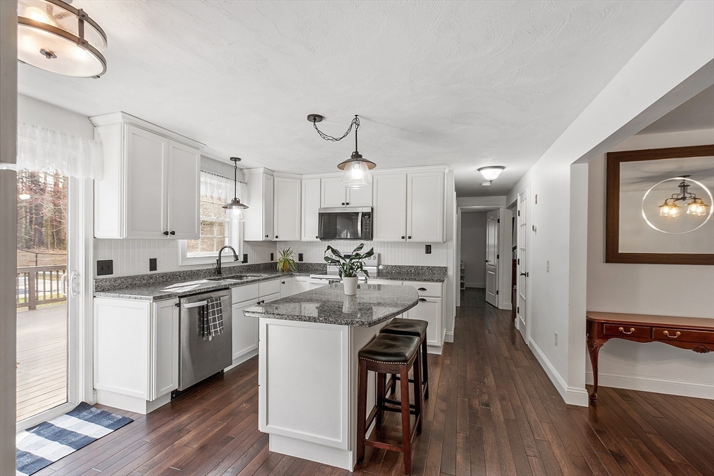 47 Brooks Village Road Phillipston, MA 01331 - Photo 9 of 41 a kitchen with stainless steel appliances a white stove top oven a sink dishwasher and white cabinets with wooden floor