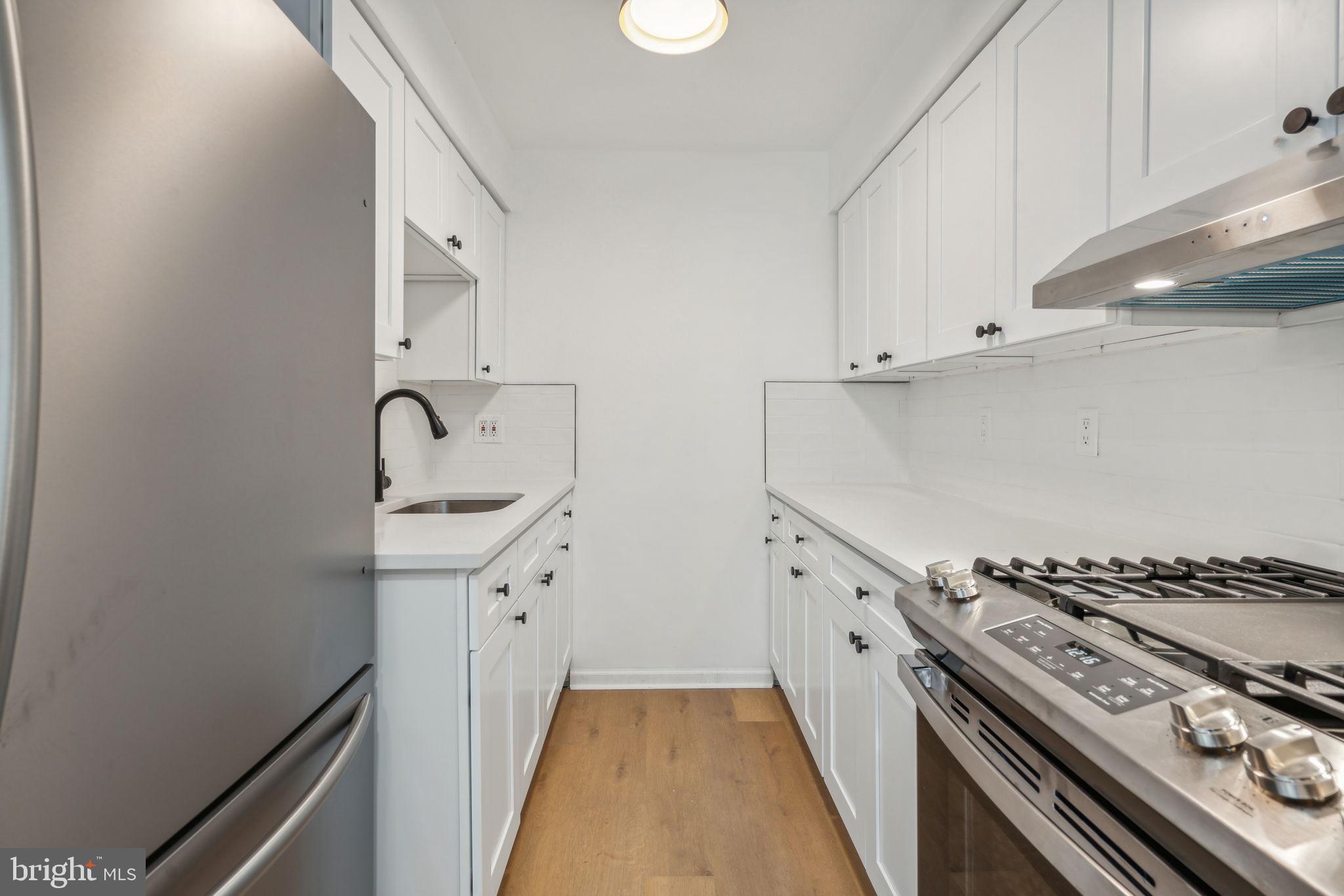 6901 Valley Avenue, Unit D1 Philadelphia, PA 19128 - Photo 5 of 19 a kitchen with a stove and a sink
