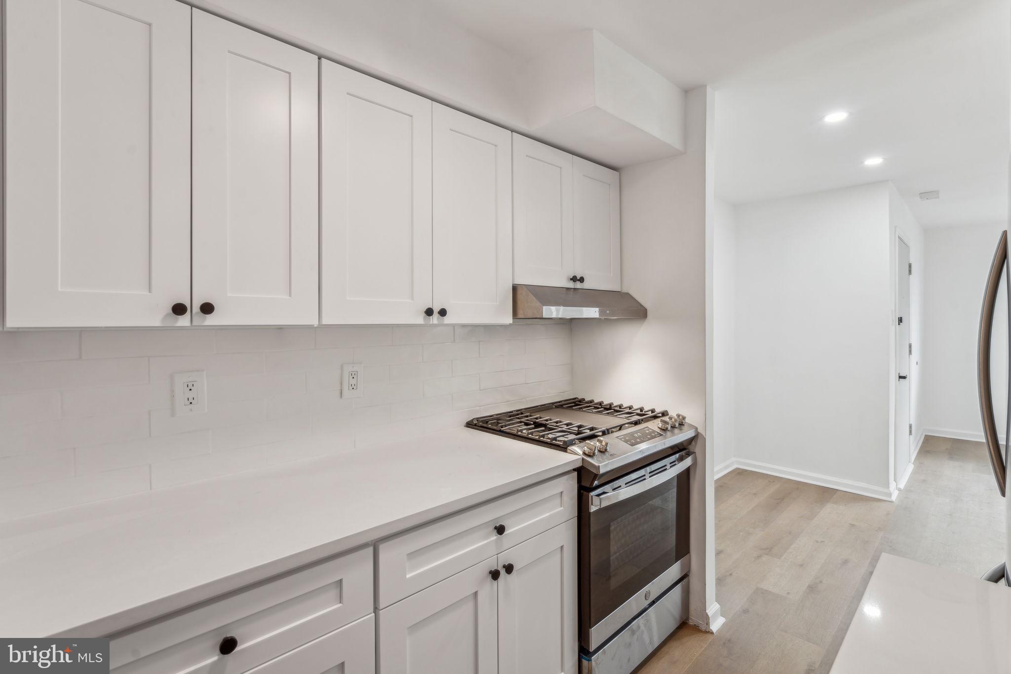 6901 Valley Avenue, Unit D1 Philadelphia, PA 19128 - Photo 6 of 19 a kitchen with granite countertop white cabinets and white appliances