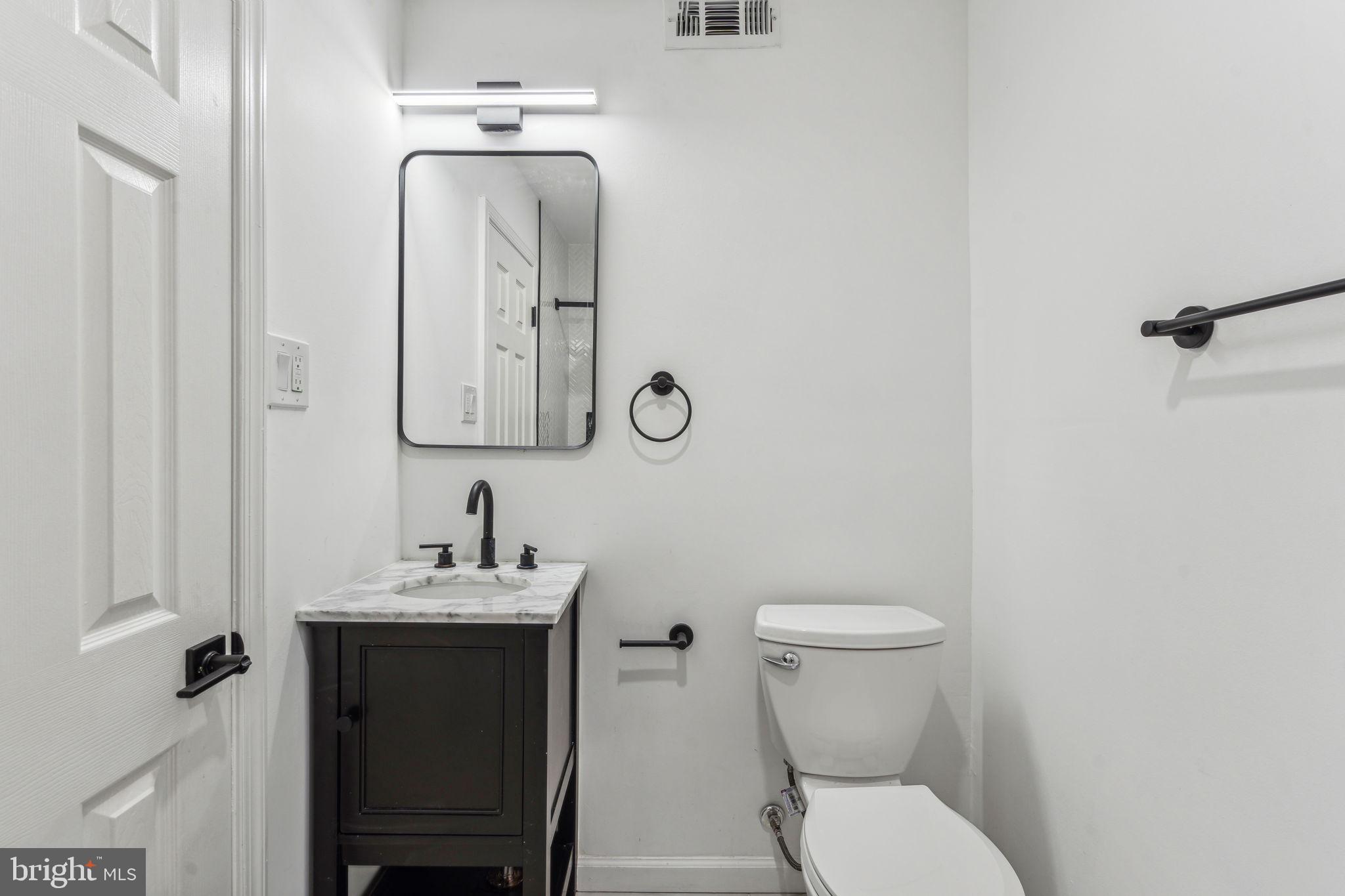 6901 Valley Avenue, Unit D1 Philadelphia, PA 19128 - Photo 9 of 19 a bathroom with a toilet sink and mirror