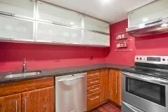 a utility room with granite countertop cabinets and stainless steel appliances