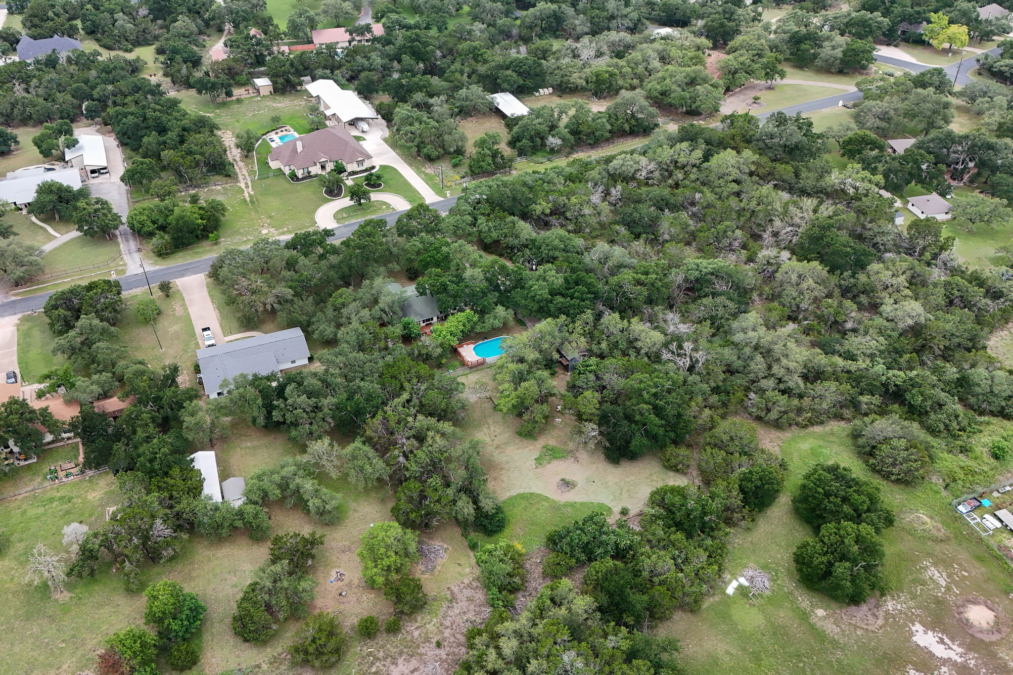 136 Valley View Road Georgetown, TX 78633 - Photo 40 of 40 Drone shot showing the gorgeous acre lot covered in trees with a large open space in the back.