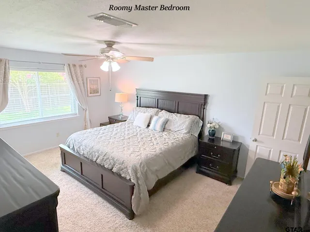 a bedroom with a bed dresser and a window