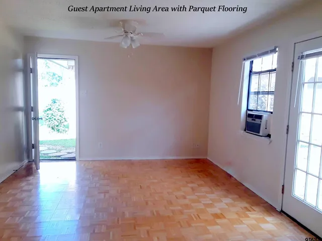 an empty room with wooden floor and windows