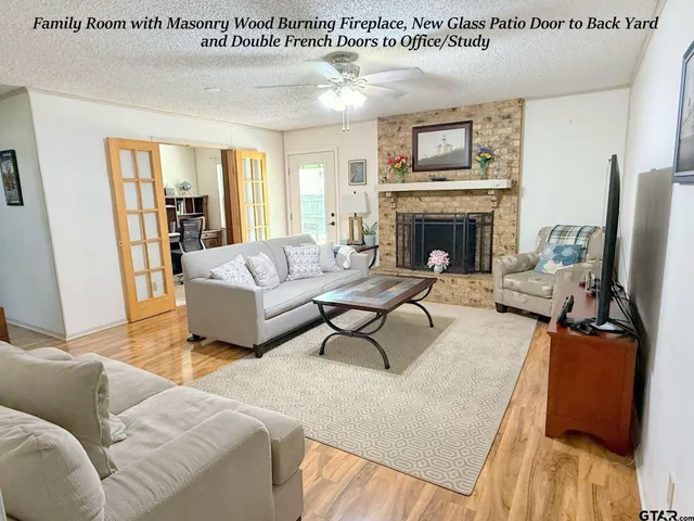 a living room with furniture a fireplace and a large window