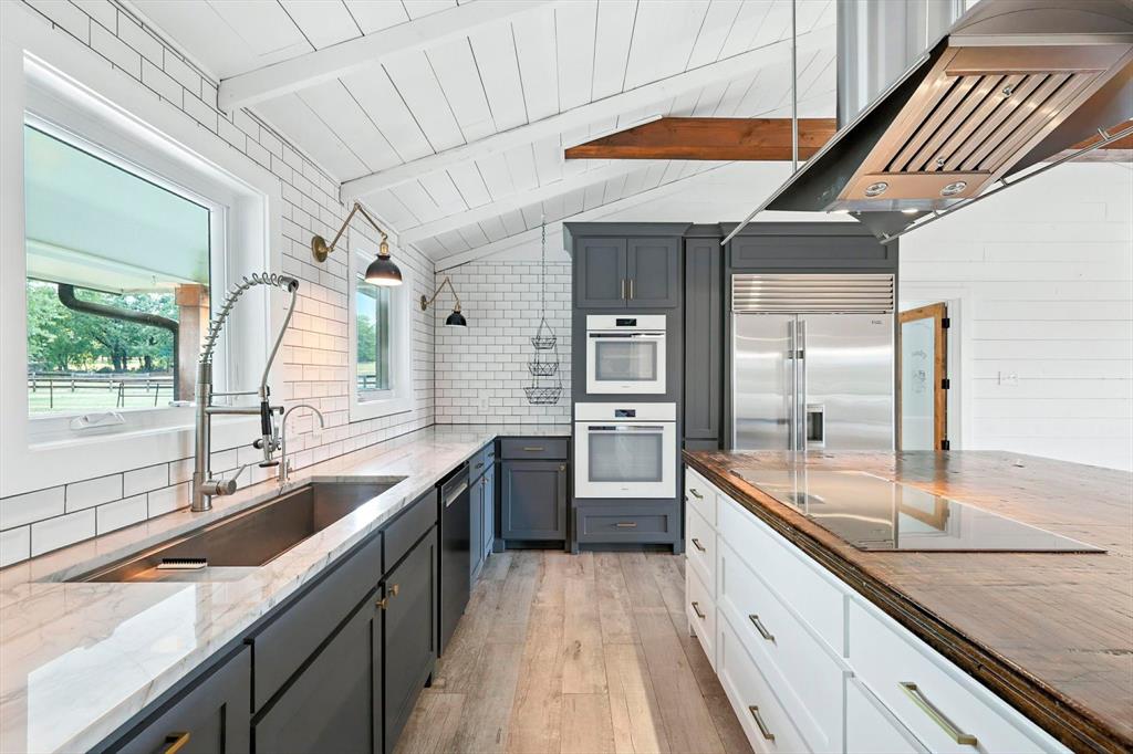 180 East Harpole Road Argyle, TX 76226 - Photo 11 of 38 a large kitchen with kitchen island a large counter space sink and stove