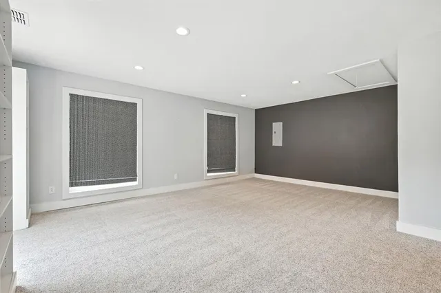 a view of a big room with windows and chandelier fan