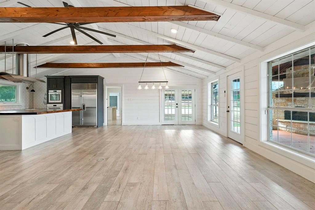 180 East Harpole Road Argyle, TX 76226 - Photo 7 of 38 a view of an empty room with wooden floor and a kitchen