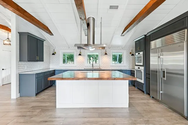 a kitchen with stainless steel appliances granite countertop a sink and dishwasher a stove with wooden floor