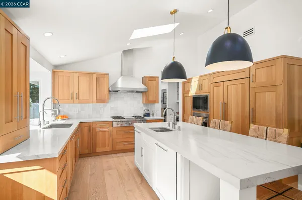 a kitchen with stainless steel appliances a table and chairs in it