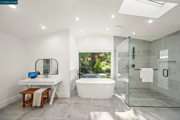 a white bath tub sitting in a bathroom next to a window
