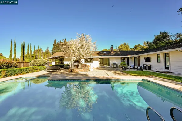 a view of a house with swimming pool and sitting area